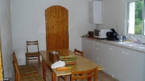 A compact kitchen with a dining table, chairs, a microwave, and a window. - Recent villa in quiet traditional neighborhood (Andernos-Les-Bains)