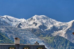 A mountain landscape with snow-covered peaks and a clear blue sky.