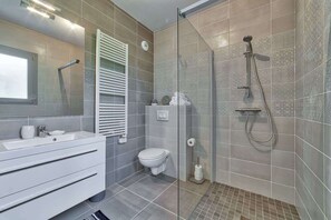 A modern bathroom with a glass-enclosed shower, a white sink, and a toilet. - Basecamp Town Centre 2 Bed Ground Floor Apartment with Terrace (Chamonix-Mont-Blanc)