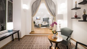 A hotel room with a bed, a chair, a table, and a decorative vase with flowers. - AMORE RENTALS - Villa Mimosa with Private Pool, Sea View, Air Conditioning, Positano Center (Positano)