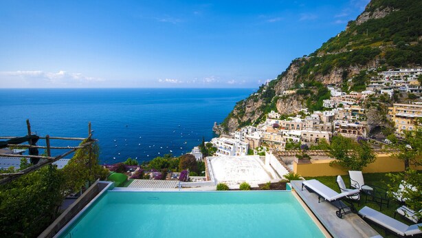 A pool area with a view of a coastal town and the sea. - AMORE RENTALS - Villa Mimosa with Private Pool, Sea View, Air Conditioning, Positano Center (Positano)