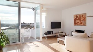 A modern living room with a balcony, a flat-screen TV, a sofa, and a painting. - beautiful (Sitges)