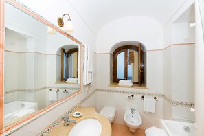 A bathroom with a large mirror, a sink, a toilet, and a bidet. - AMORE RENTALS - Villa Zeus with private Pool, Sea View, Terraces and Air Conditioning (Positano)