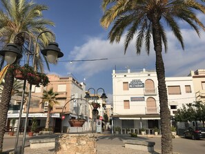 A street with palm trees, a restaurant named 'Casa Esquerria Restaurant,' and a building with a sign 'Langostinos.' - Villa by the sea with private pool and wifi (Las Casas de Alcanar)