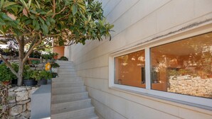 A staircase leading to a window with a view of a stone wall and potted plants. - 3 bedroom beautiful apartment in Makarska (Makarska)
