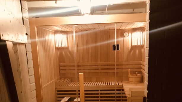 A sauna with wooden benches and a bench with a sink.