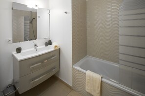Banheira, secador de cabelo, toalhas de banho, papel higiênico