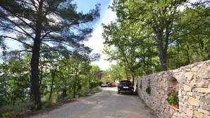 A gravel road flanked by stone walls and trees. - 'MARJOLAINE' Gite T2 / VIEW OF THE LAKE 200 m away from the beaches (BAUDUEN)