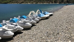 A row of small boats with blue covers labeled T1, T2, and T3, docked on a pebble beach with a forested hill in the background. - 'MARJOLAINE' Gite T2 / VIEW OF THE LAKE 200 m away from the beaches (BAUDUEN)