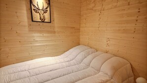 A single bed in a wooden room with a deer head decoration on the wall. - DAILLE  S18 - 4 PERS - WIFI - SWIMMING POOL ACCESS - SAINT JEAN D'AULPS RESORT - NEAR MORZINE (Saint-Jean-d´Aulps)