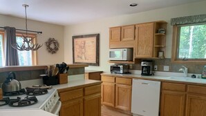 A kitchen with wooden cabinets, a gas stove, a microwave, and a dishwasher.