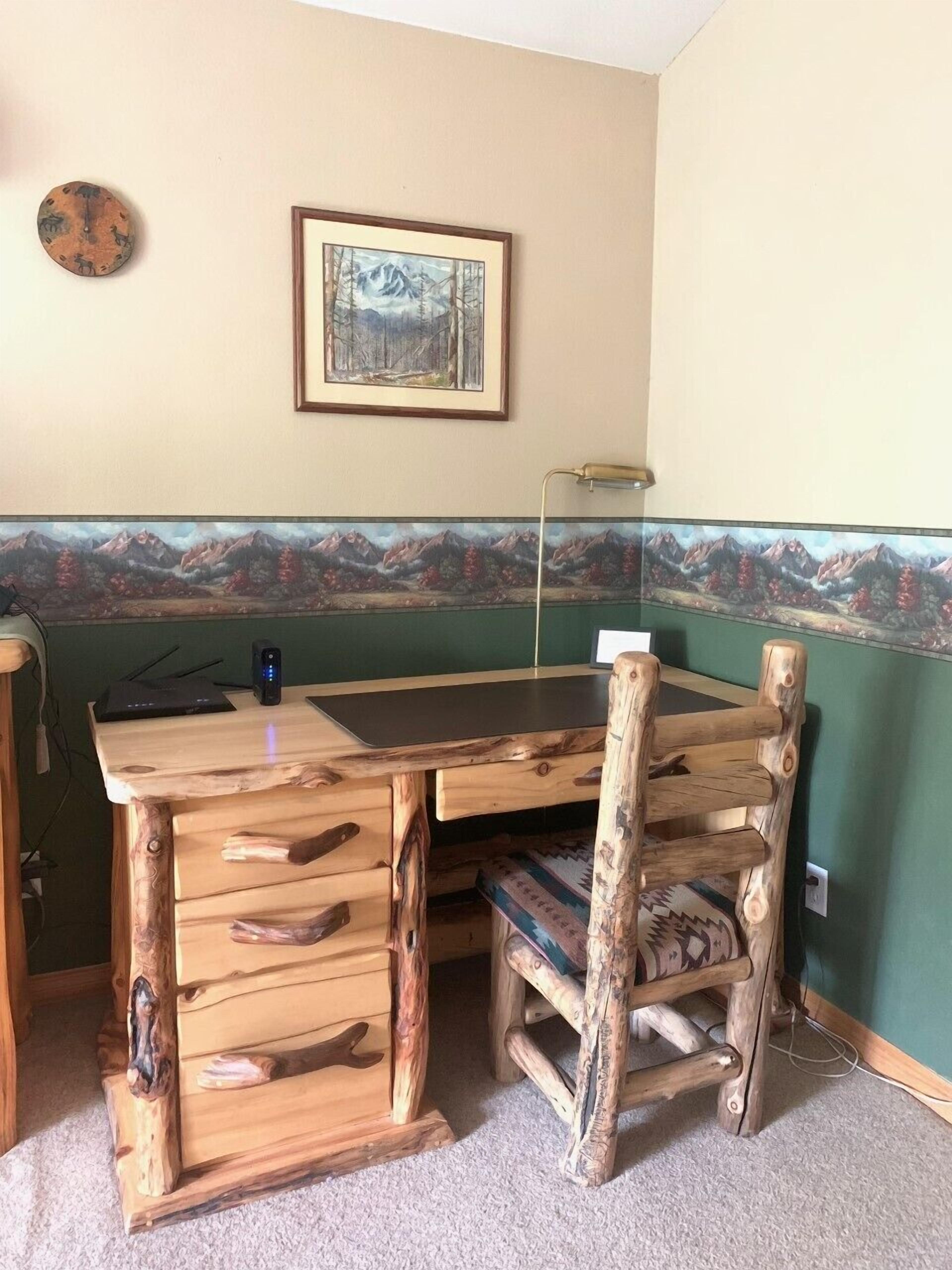 Un tavolo da pranzo in legno dal design rustico, con un quadro incorniciato sopra e un pavimento con tappeto.