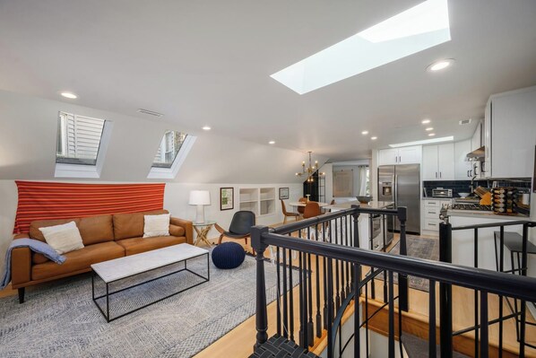 A modern apartment with a living room, dining area, kitchen, and a staircase leading to an upper level. - Unique Chicago Penthouse Loft - Amazing Deal & Location (Chicago)