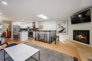 A modern kitchen with white cabinets, a central island, and a dining area with a marble table. - Unique Chicago Penthouse Loft - Amazing Deal & Location (Chicago)