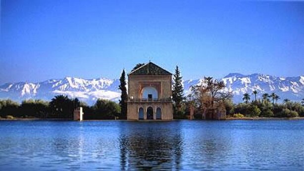A building with a central dome and arched windows, surrounded by water and mountains in the background. - A change of scenery guaranteed: TV apartment, WIFI, Car park (Marrakech)