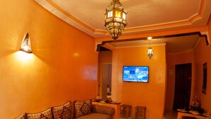 A living room with a sofa set, a coffee table with fruit, and a television. - A change of scenery guaranteed: TV apartment, WIFI, Car park (Marrakech)