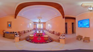 A spacious living area with a central coffee table, sofas arranged around it, and a television mounted on the wall. - A change of scenery guaranteed: TV apartment, WIFI, Car park (Marrakech)
