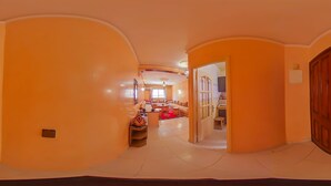 A spacious hallway with a wooden door on the right, leading to a living area with a sofa and a TV. - A change of scenery guaranteed: TV apartment, WIFI, Car park (Marrakech)