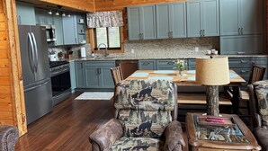 A wooden cabin interior with a kitchen, dining area, and seating. - Nature lovers paradise w/direct access to lake,  trails & ample trailer parking. (Atlanta)
