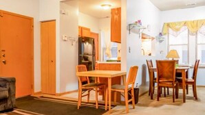 Un espace de vie compact comprenant un coin repas, une cuisine et un petit coin salon.