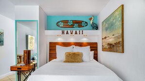 Ein Hotelzimmer mit einem großen Bett, einem hölzernen Kopfteil, einer türkisfarbenen Wand mit einem 'HAWAII'-Schild und einem Landschaftsbild.