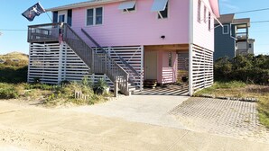 A pink house with a wooden staircase and a flag.
