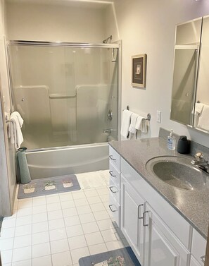 Een bad/douchecombinatie, een haardroger, handdoeken, zeep