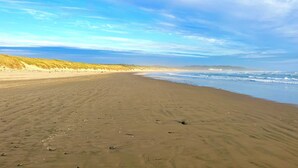 A sandy beach with dunes and a clear sky.