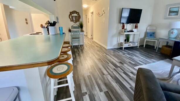 Une cuisine moderne avec un coin bar, des tabourets en bois et une table à manger.