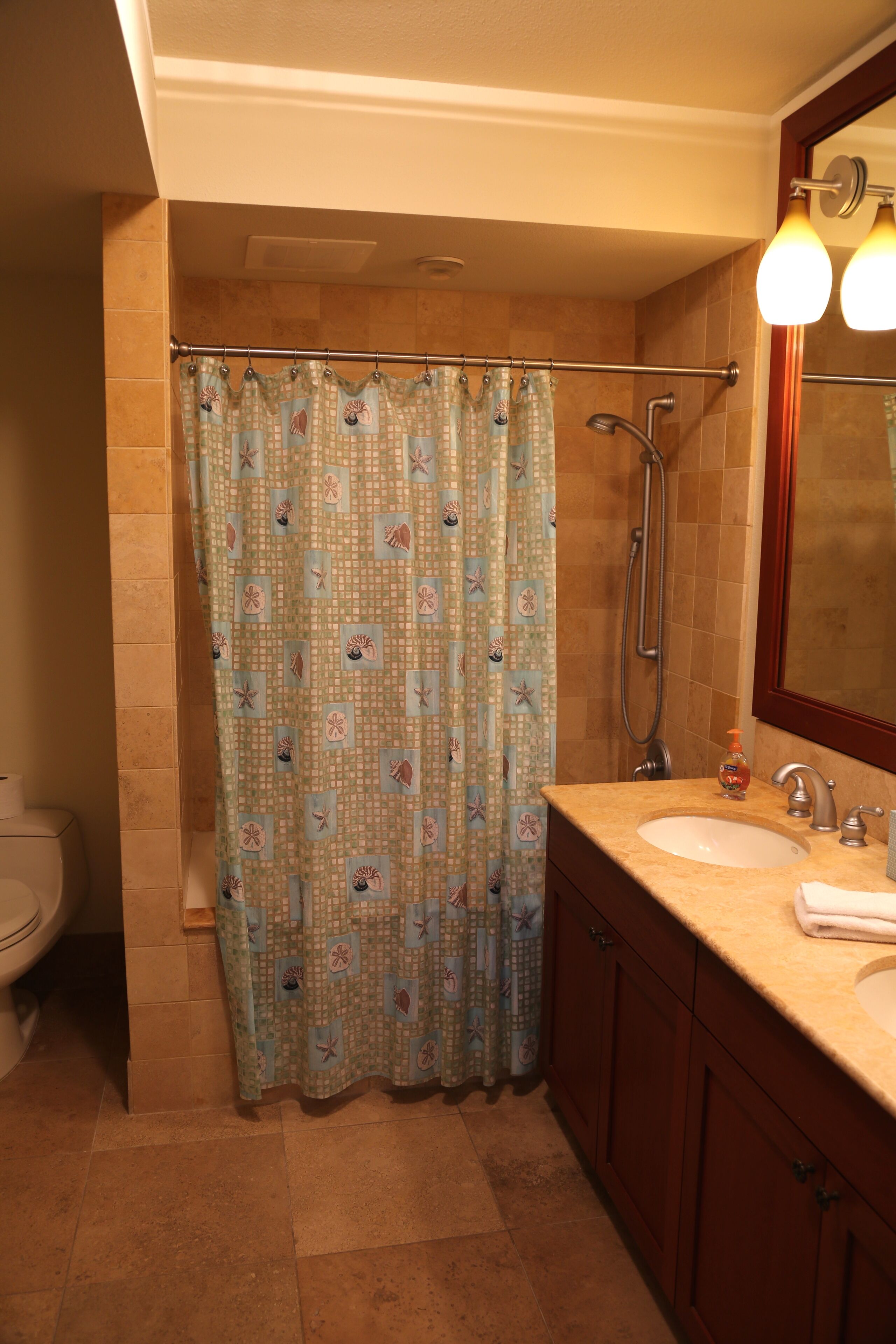Ein Badezimmer mit Dusche, Toilette und Waschbecken.