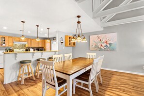 A modern kitchen with wooden cabinets, a central island, and pendant lighting.