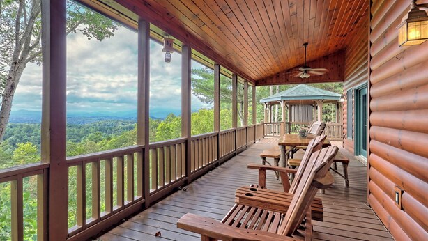 Una terraza de madera con vista a un paisaje boscoso.