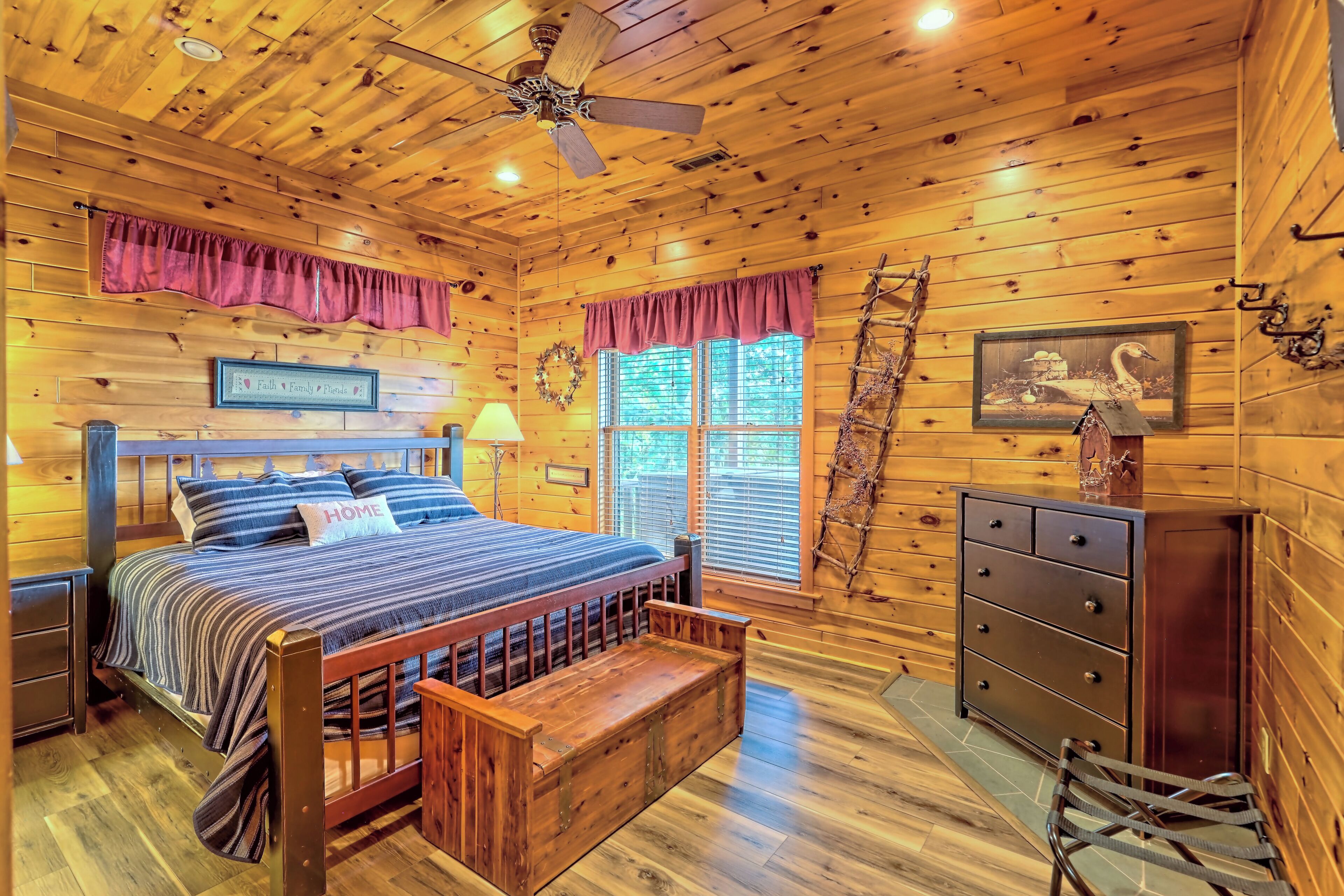 A wooden cabin bedroom with a bed, dresser, and a ladder.