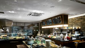 A well-lit buffet area with various food items and beverages, a brick wall, and modern kitchen equipment. - DEL style Osaka - Shinsaibashi by Daiwa Roynet Hotel (Osaka)