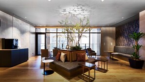 A modern lobby with a seating area, a coffee station, and a large window offering a view of the city. - DEL style Osaka - Shinsaibashi by Daiwa Roynet Hotel (Osaka)