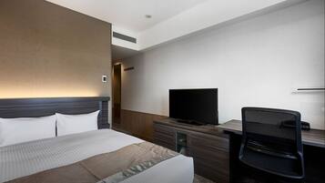 A hotel room with a bed, a desk, a chair, a television, and a mirror.