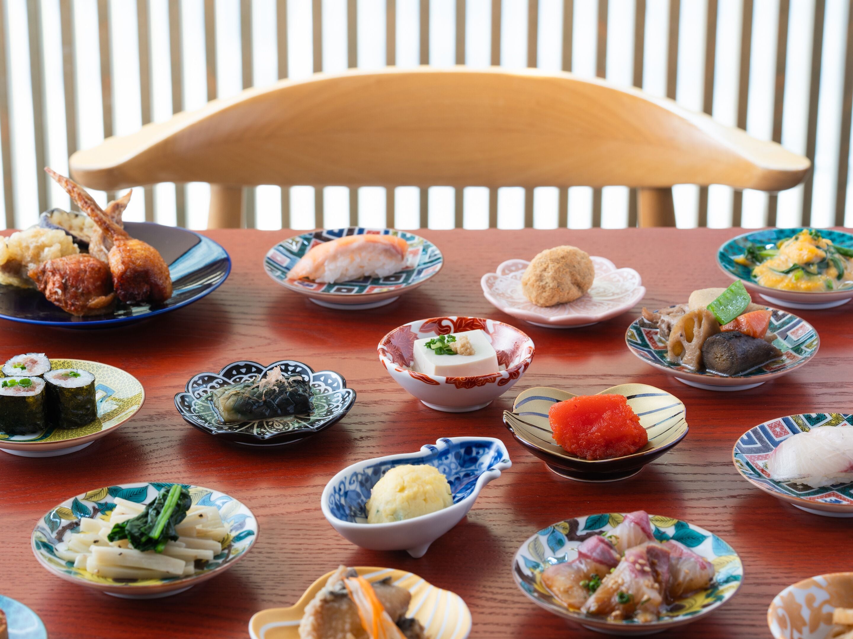 Uma mesa de jantar de madeira com diversos pratos japoneses.