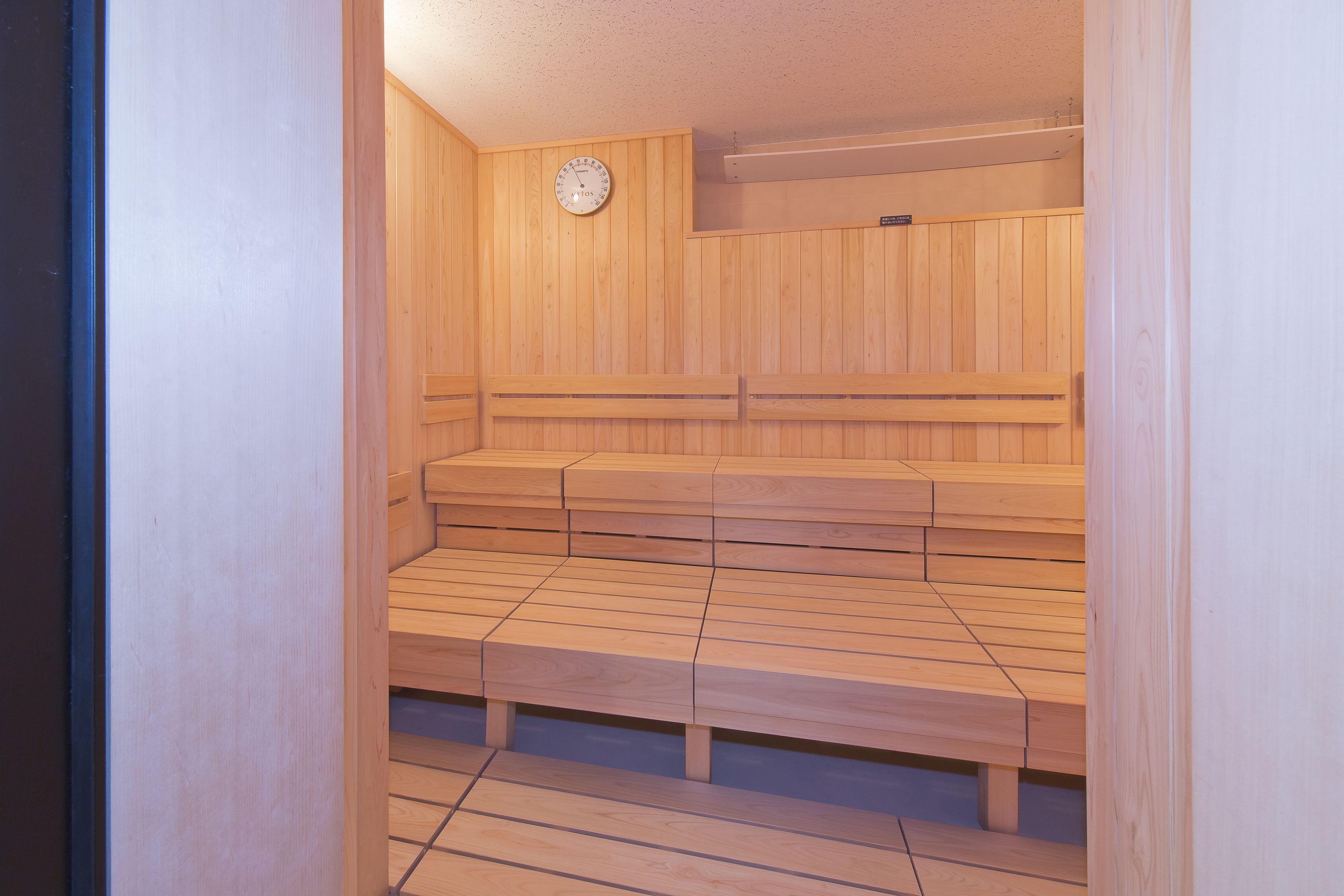 Una sauna con panche in legno e un orologio appeso al muro.