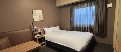 Una habitación de hotel con una cama individual, un escritorio y una silla.