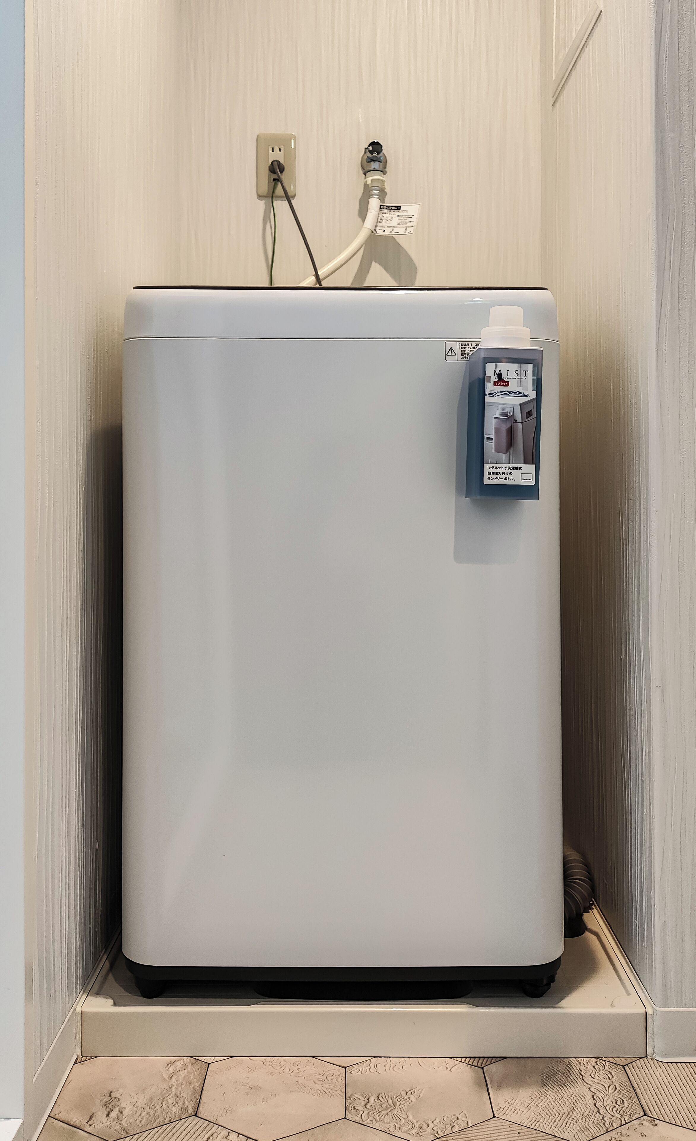 A white water heater with a control panel, connected to a wall outlet.