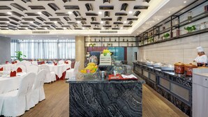 Un comedor moderno con encimeras de mármol, una isla central y una zona de cocina con estantes que exhiben diversos objetos.