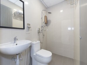 A modern bathroom with a white sink, toilet, and shower. - Hotel Agro (Raub)