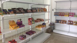 Una tienda de comestibles con estantes llenos de aperitivos y bebidas.