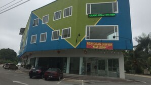 Un edificio de hotel con un letrero que dice "HOTEL AGRO" y un número de contacto.