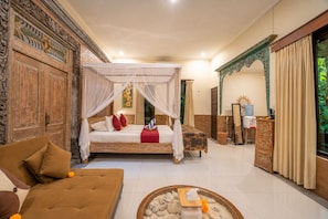 A room with a four-poster bed, a sofa, a small table with a decorative bowl, and a mirror. - Taluh Bebek Ubud Private Villas (Ubud)