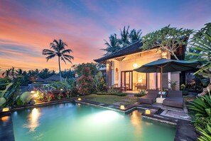 A poolside area with lounge chairs, a small pool, and a covered seating area with a view of the sunset. - Taluh Bebek Ubud Private Villas (Ubud)
