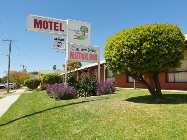 A motel with signs indicating 'Motel' and 'Country Mile Motor Inn'.