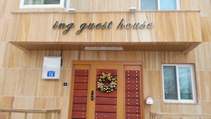 En træbygning med et skilt der siger "ing guest house".