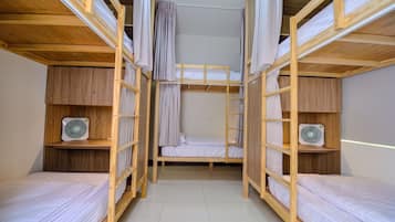 Cozy multi-level room with bunk beds, shelving, and fans for a comfortable stay.