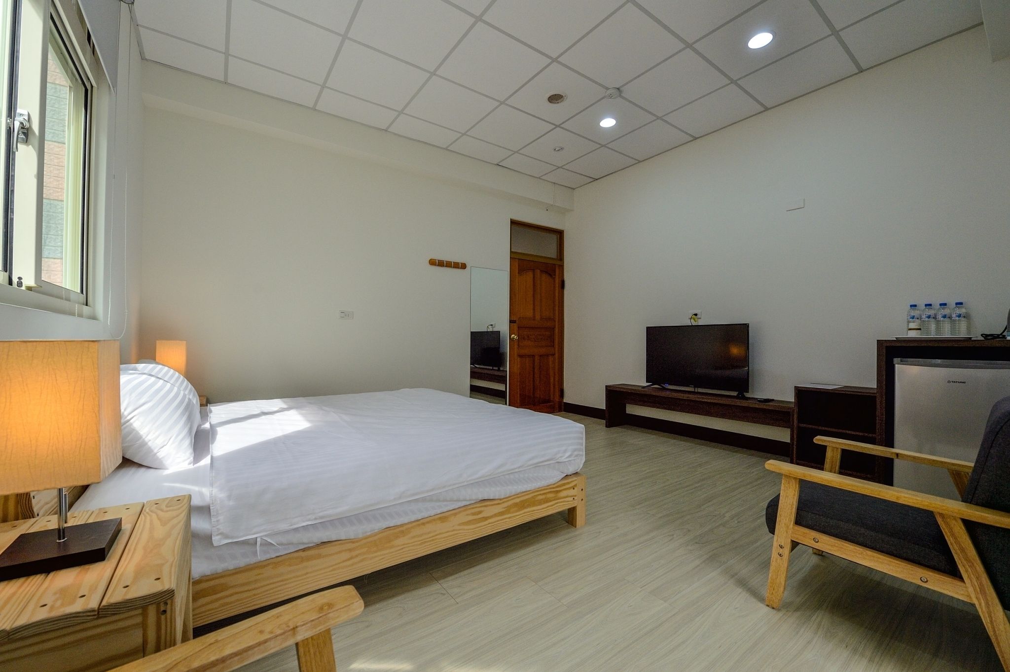 Une chambre d’hôtel avec un lit, une télévision, un bureau et une chaise.